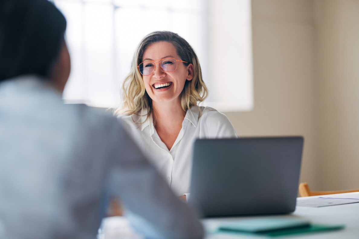 Smiling Woman in Office Setting During Business Meeting